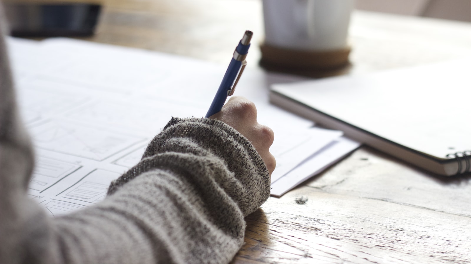 A focused workspace with a laptop, open notebooks and study materials