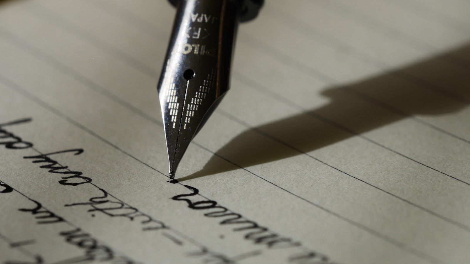 A person writing notes in a paper notebook with a pen