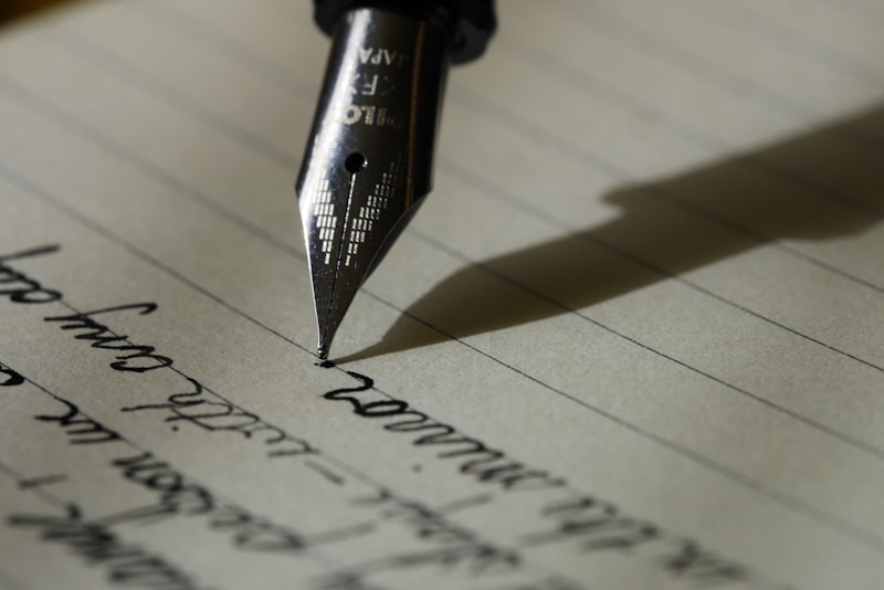 A person writing notes in a paper notebook with a pen