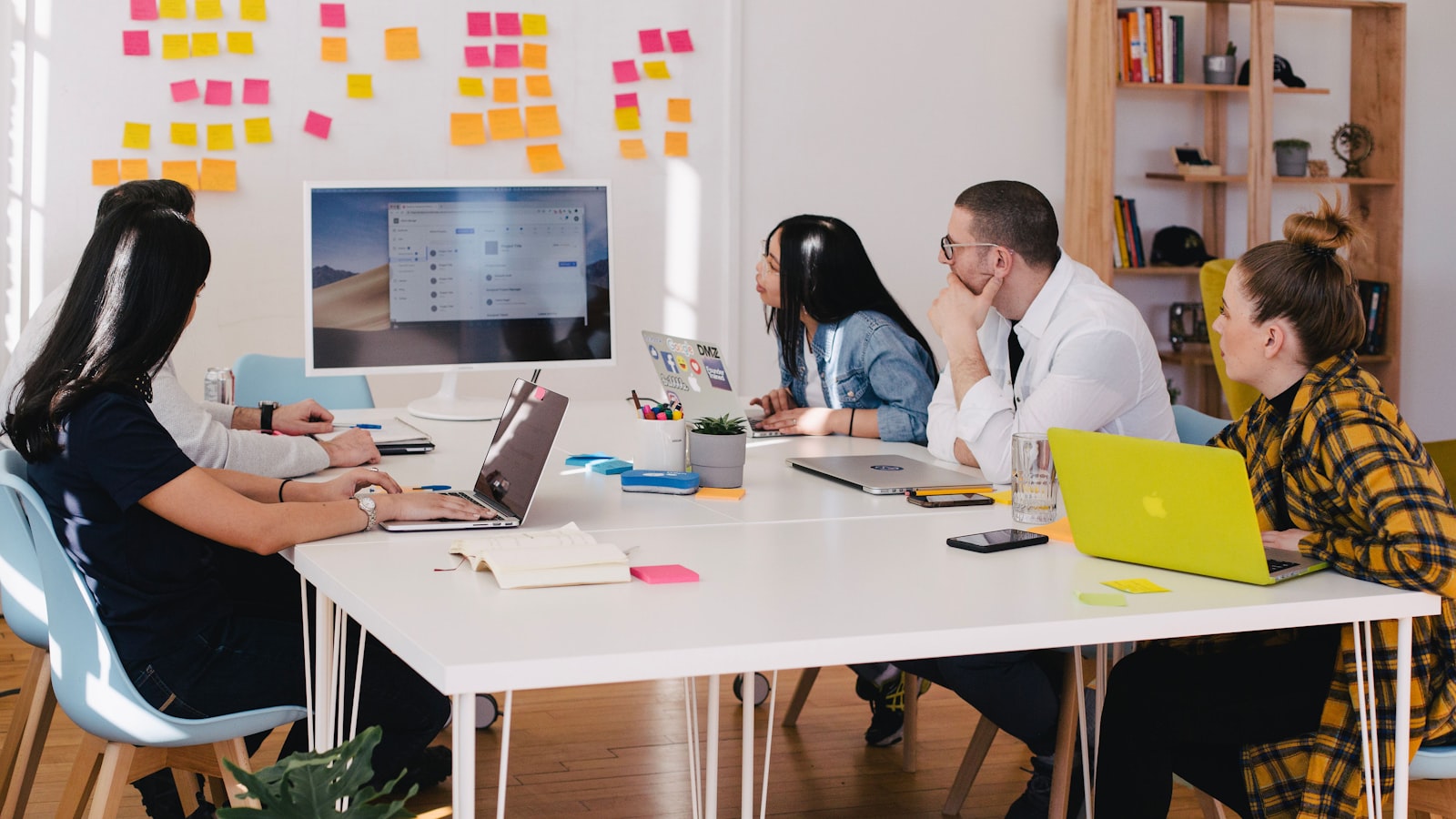 People sitting around a table discussing work with notebooks open