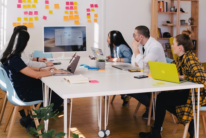 People sitting around a table discussing work with notebooks open