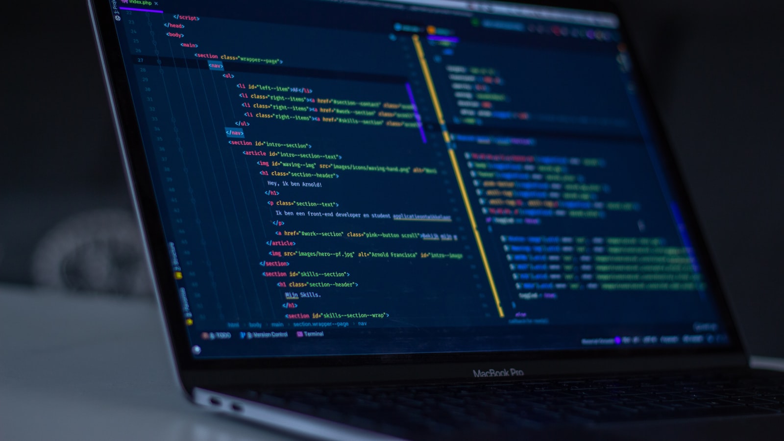 A laptop screen showing code beside a notebook on a desk