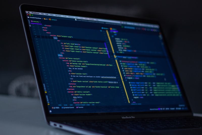 A laptop screen showing code beside a notebook on a desk